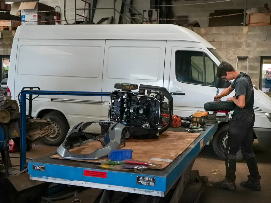 mecanicien reparant un essieu sur plateau atelier frencq agri