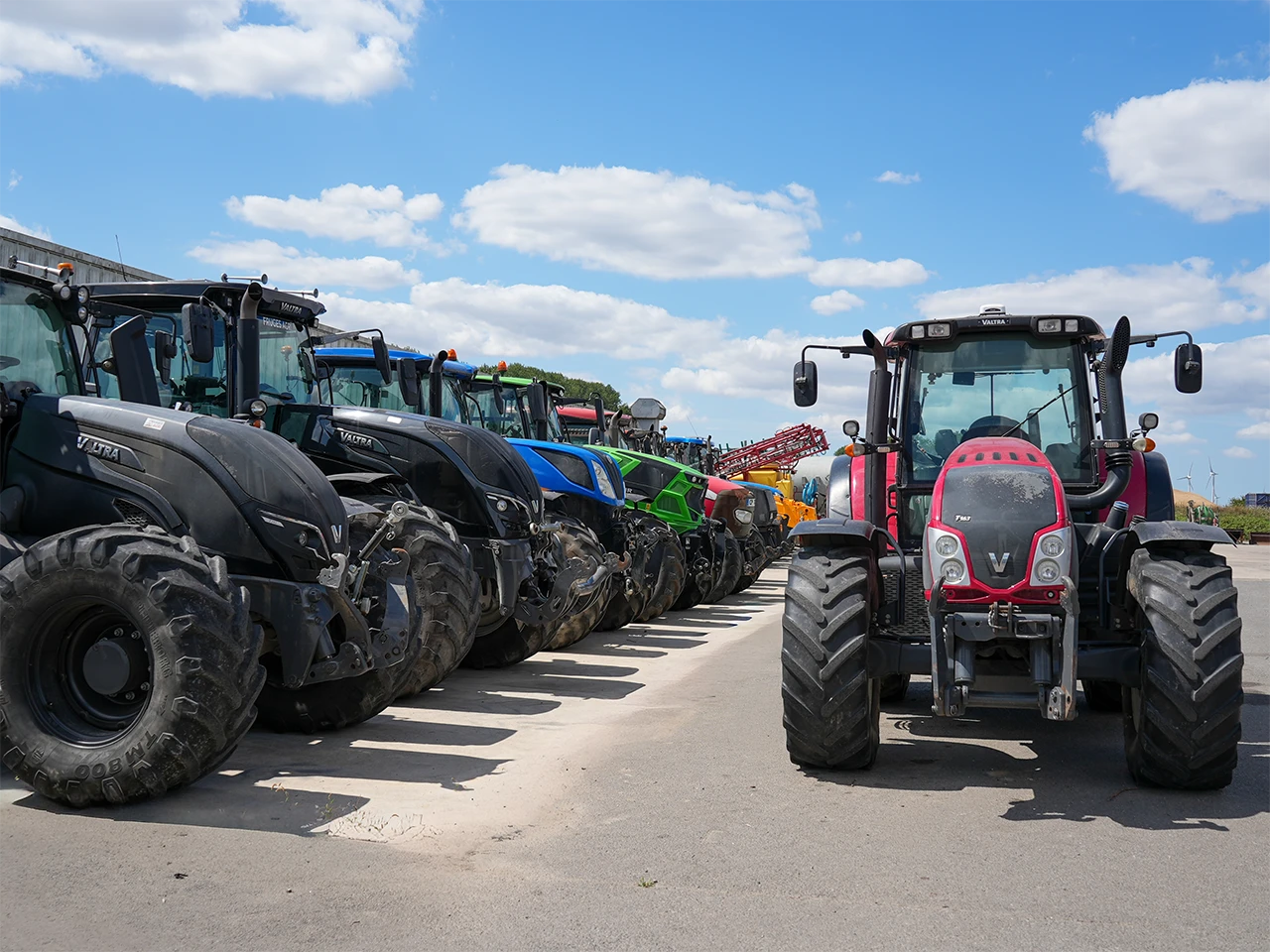 rangee de tracteurs multicolores vue de face exterieur fruges agri