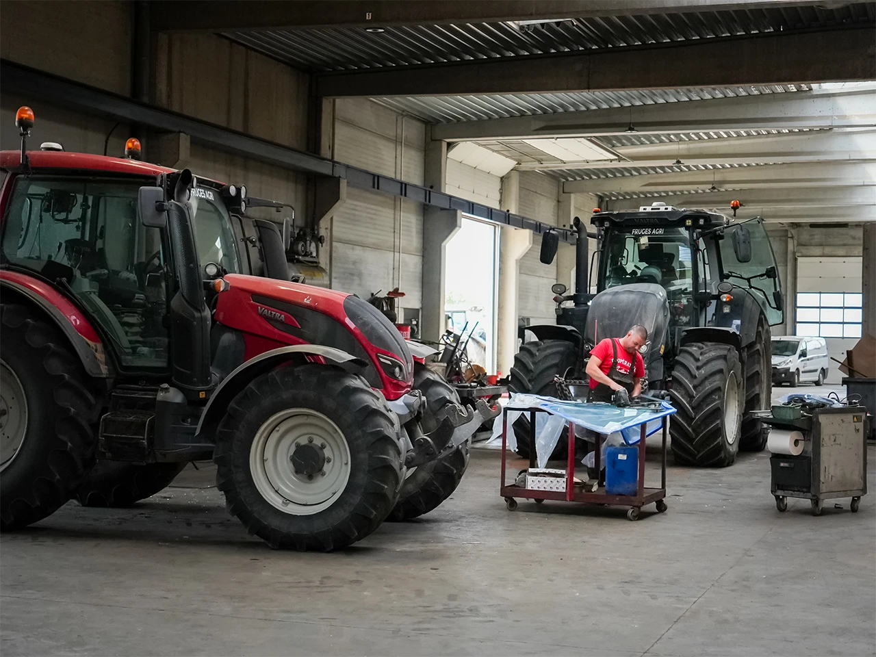 technicien reparant un tracteur rouge valtra atelier fruges agri