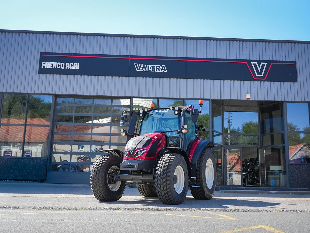 tracteur rouge de la marque valtra en exposition devant la concession frencq agri